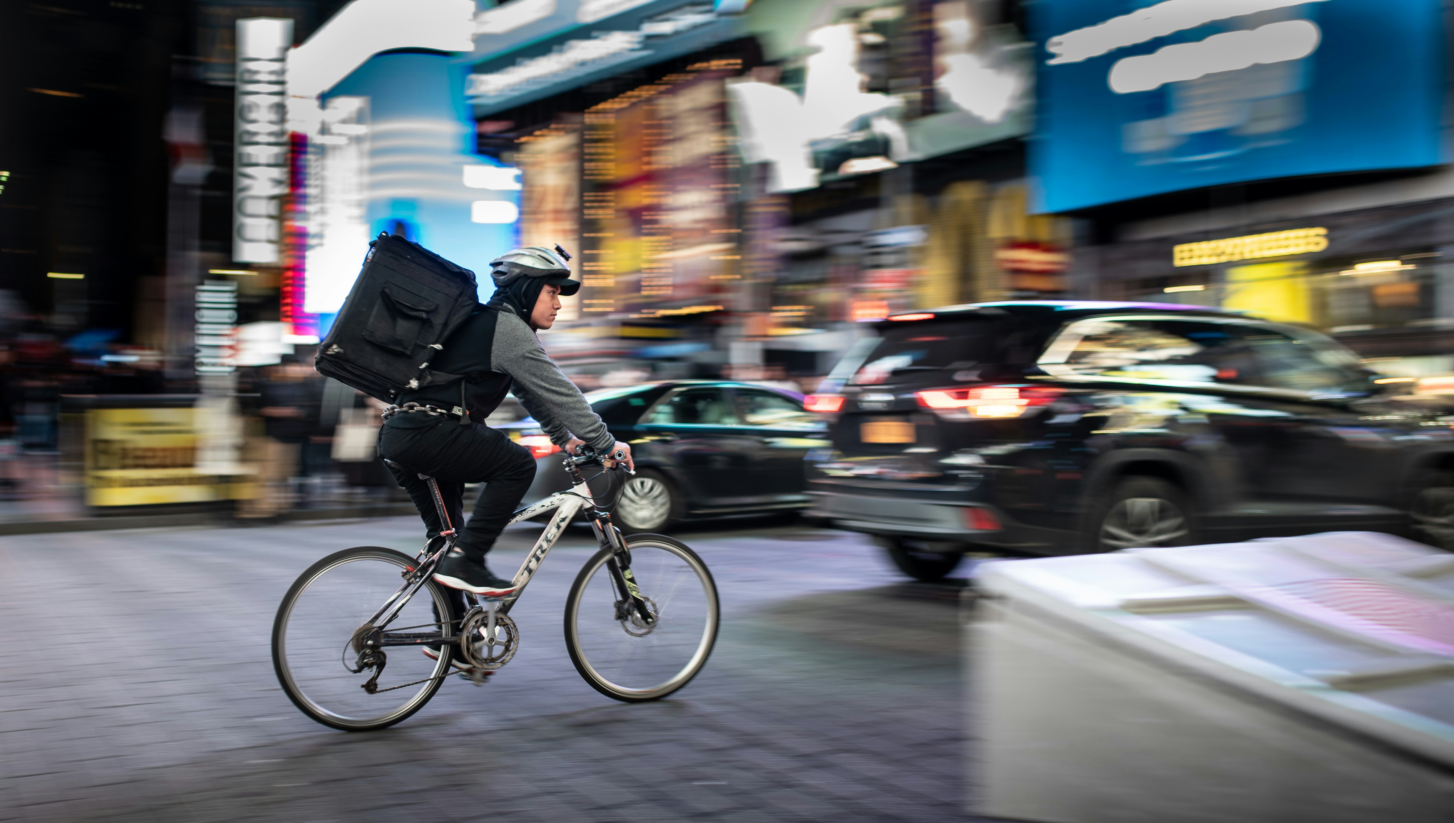 A courier riding a bike through an urban environment